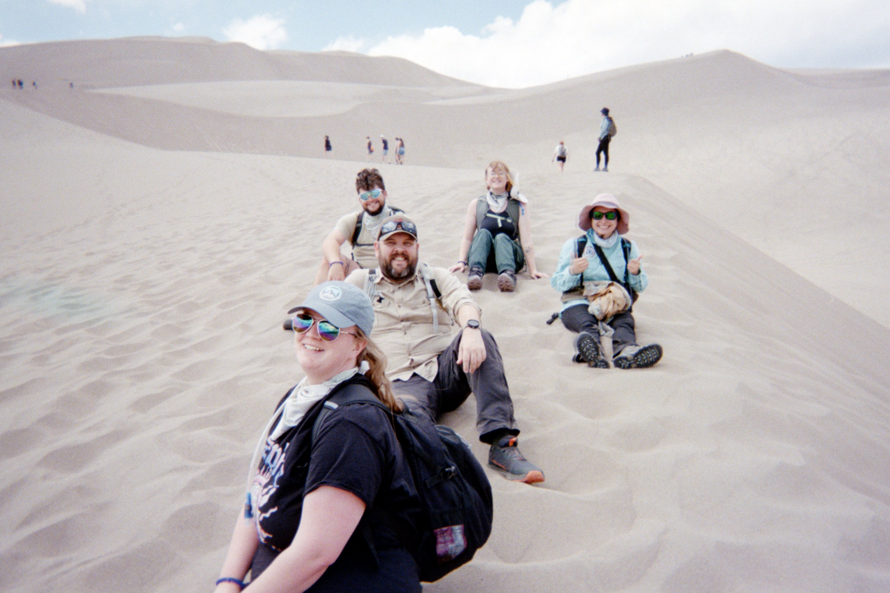 Group of geoscience students pose on the Great Sand Dunes on trip to Colorado