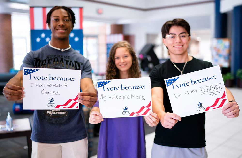 UAFS students share signs with why they registered to vote during National Voter Registration Day