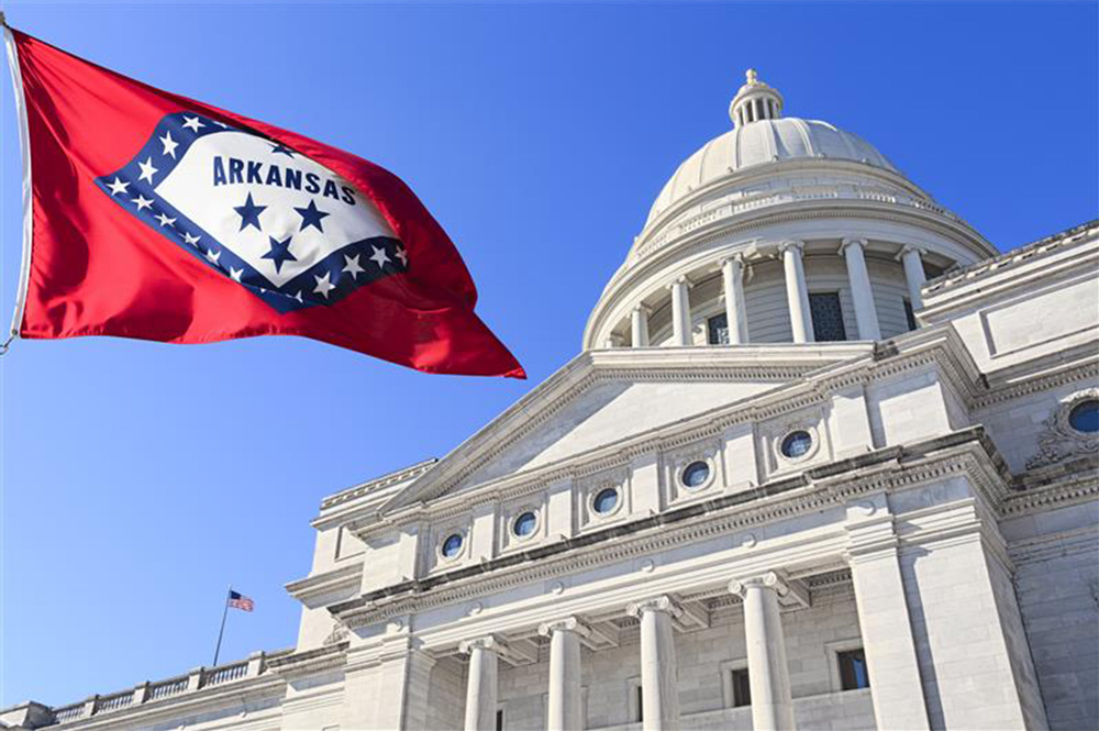 Arkansas State Capitol Building with state flag in the foreground