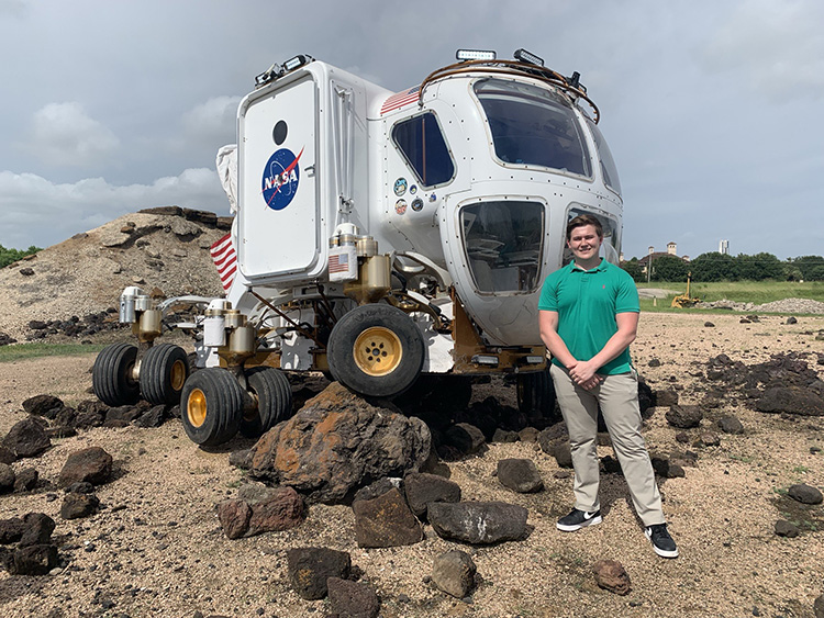 UAFS student stands in front of NASA moonrover
