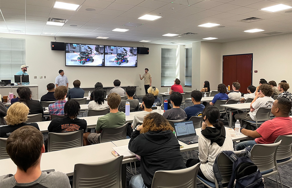 Front left to right: Cameron Taylor, Marco Garcia Montes, and Josue Martinez present 