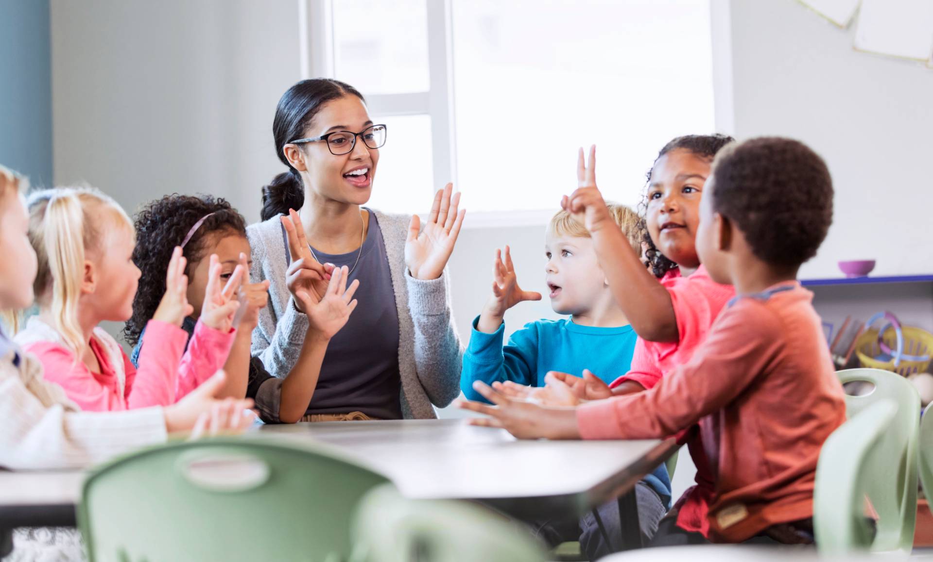 children in a pre-k classroom interact with their teacher