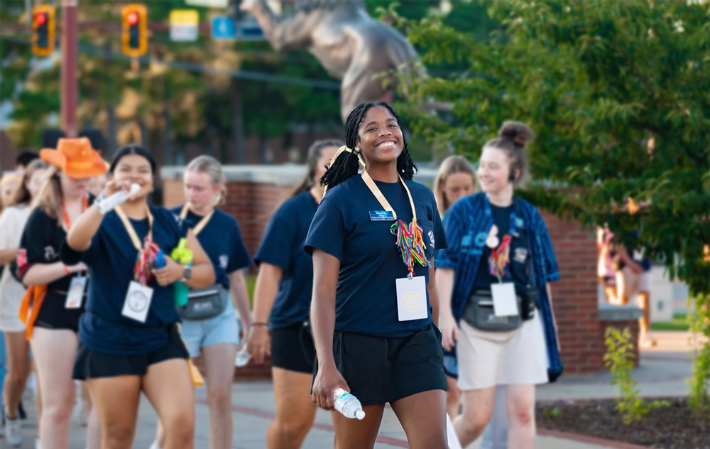 UAFS student, Erika Johnson, center, walks with other Cub Camp counselors and students outside of the Stubblefield Center.