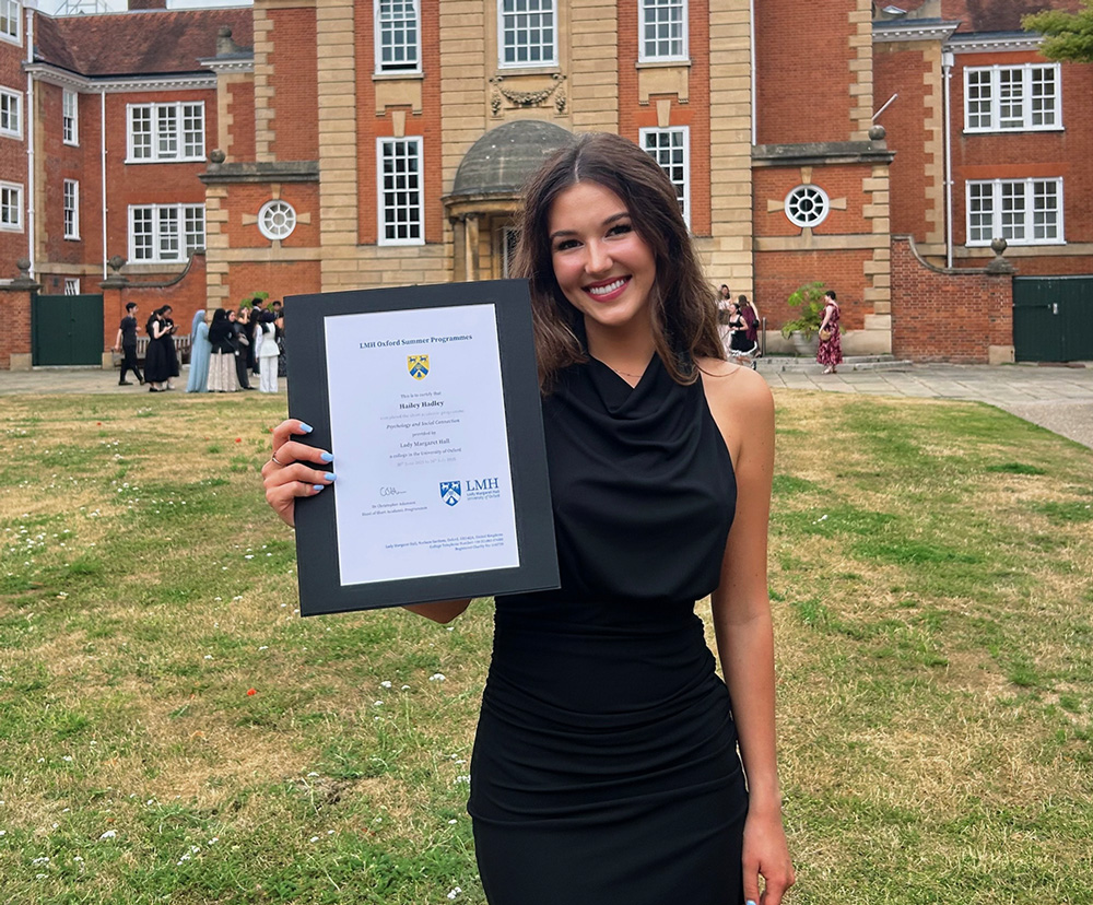 Hailey with her certificate of completion outside of Lady Margaret Hall at Oxford University