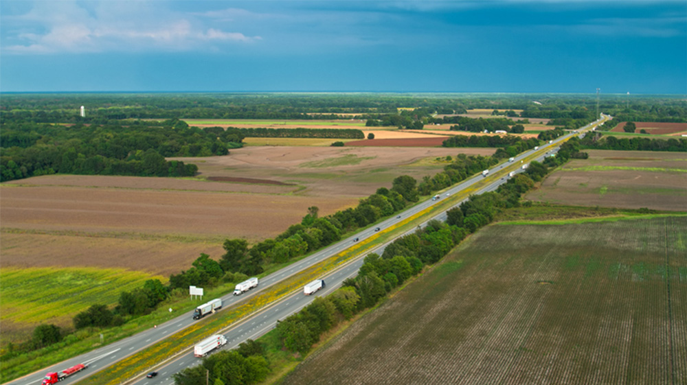 Aerial photo of an interstate cutting through farm land.
