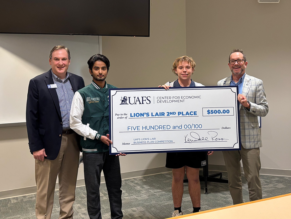 Two UAFS students from left to right, Abdur-Rehman Sajjad and Tyler Teague, accept their check for $500 after coming in second place during the thrid Lion's Lair Business Plan Competition. The students are joined by UAFS staff members, Ty Barrett and Kendall Ross.