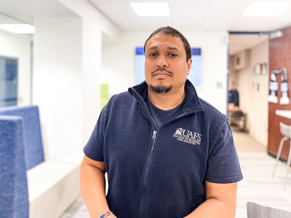 Nigel Otero, advising coordinator, College of Business and Industry, stands outside of his office on the second floor of the Flanders Building