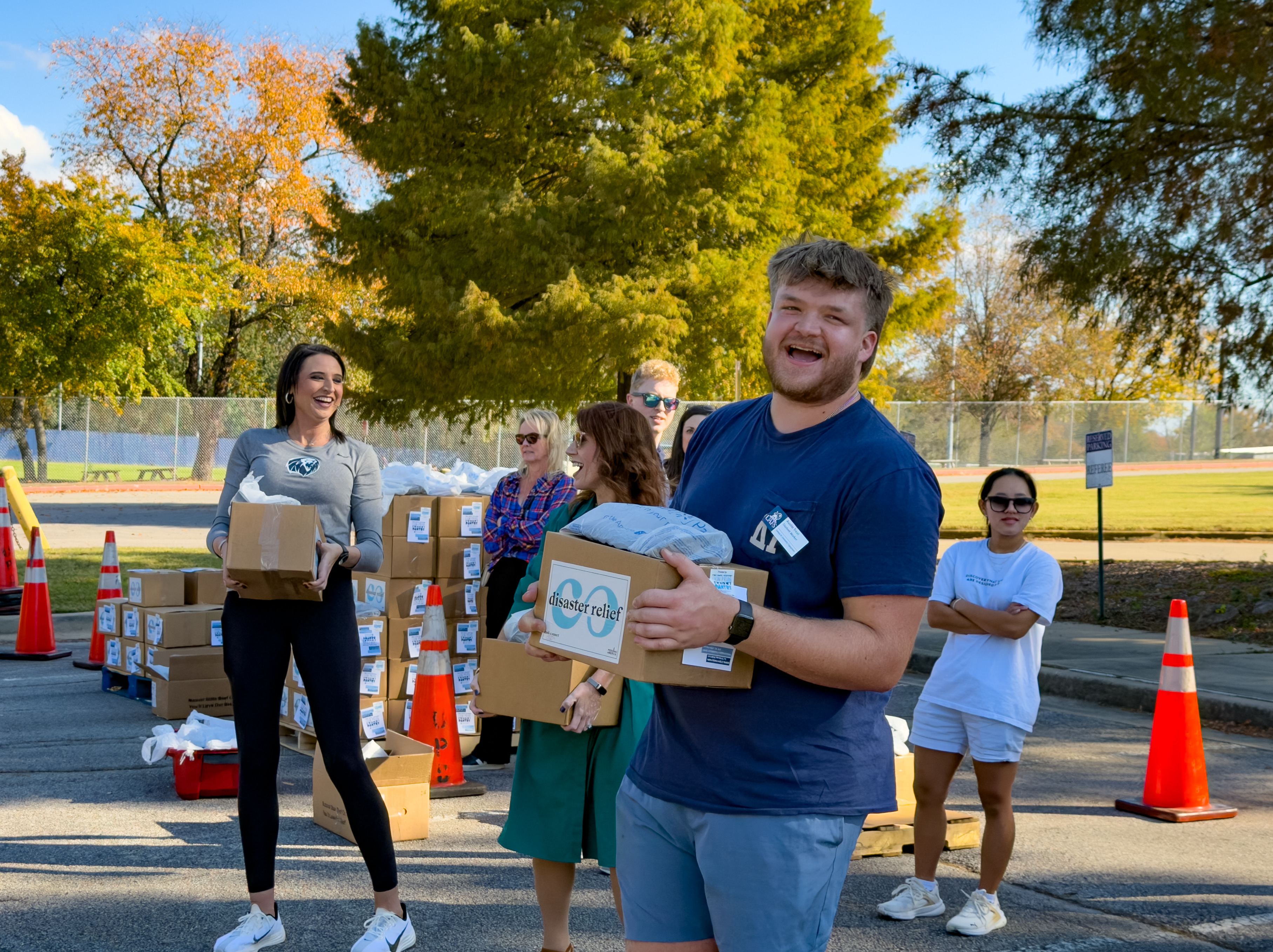Students load boxes of food into cars during a food giveaway at UAFS