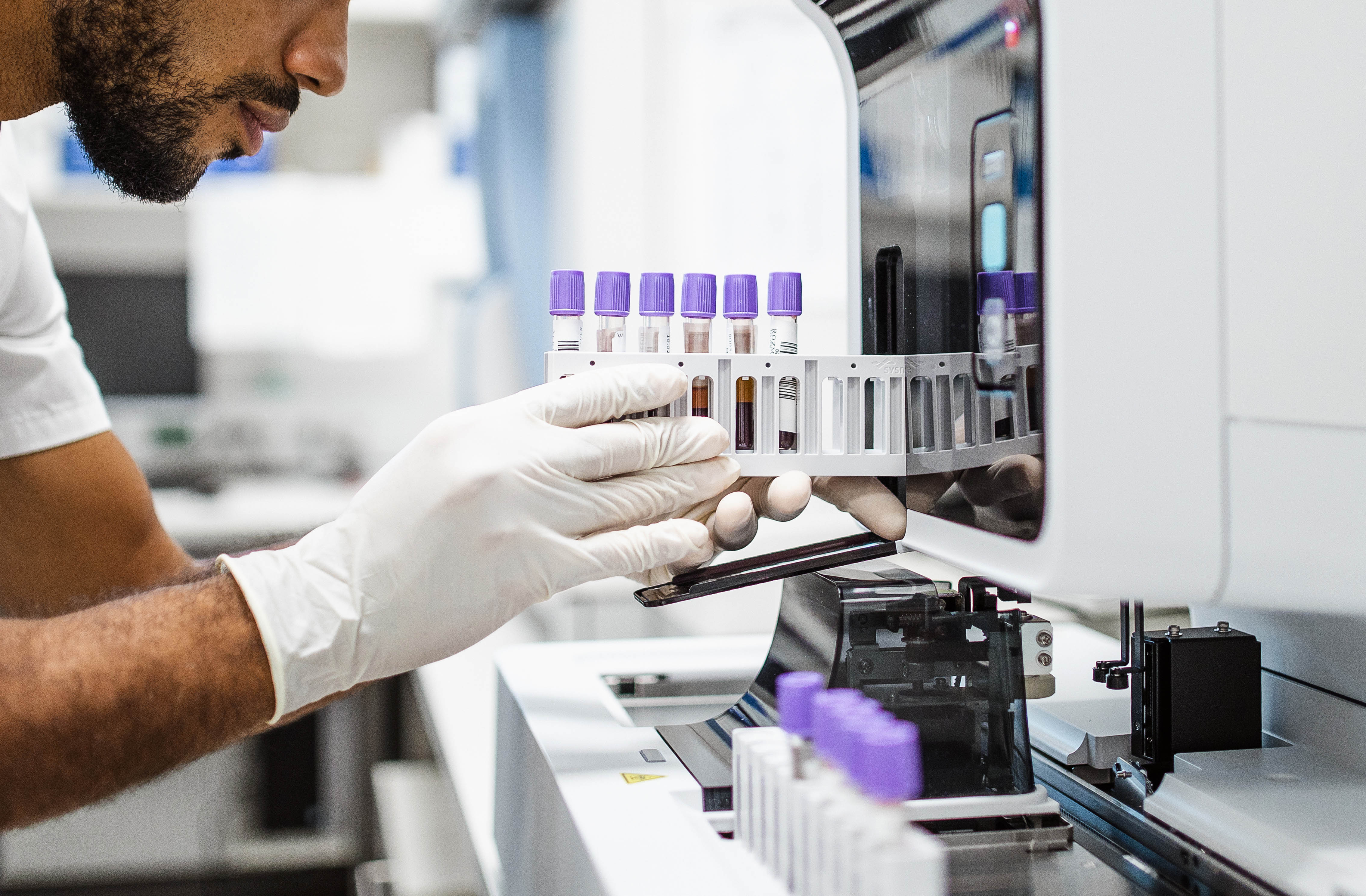 A student loads cell samples into a machine for testing