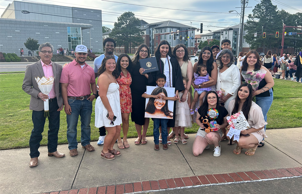 Sarahi Ibarra (center) is surrounded by family and friends during her spring 2025 graduation from UAFS